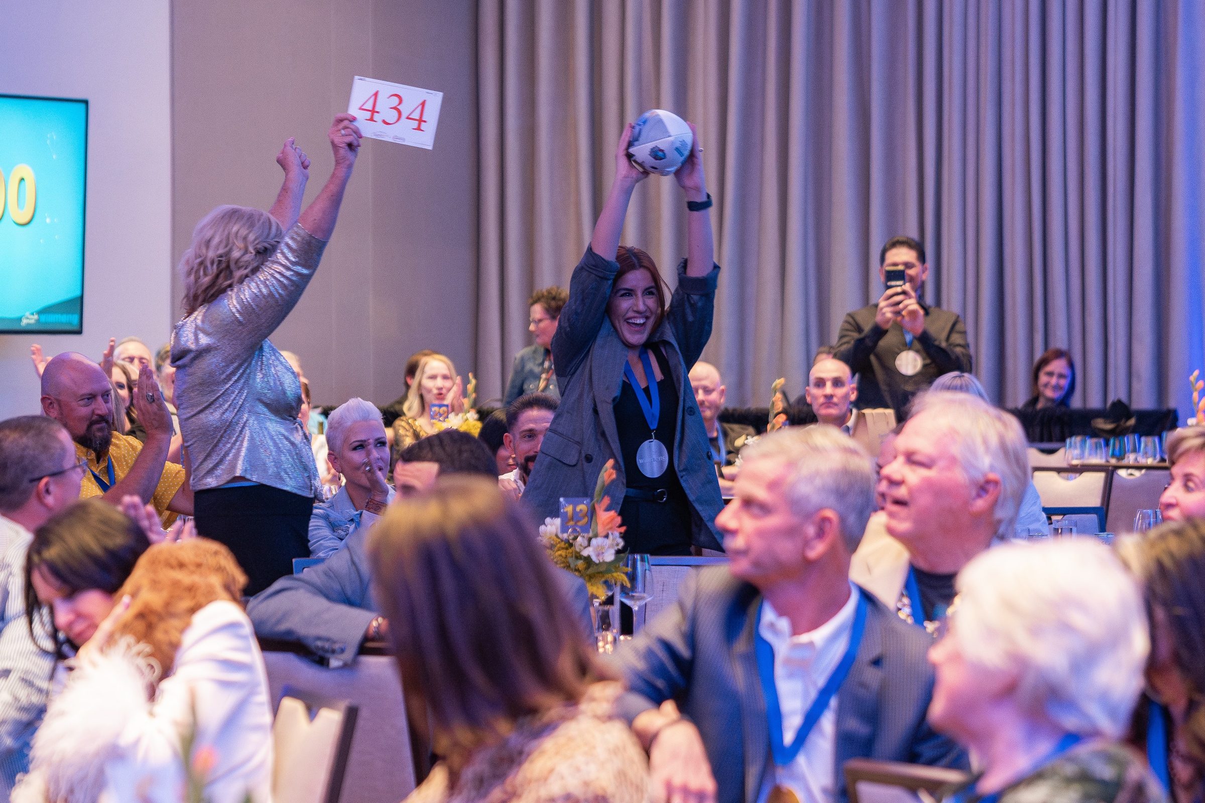 Guests raising bid paddles at a Treasure House event
